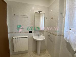 een badkamer met een wastafel en een spiegel bij AGOS in San Vincenzo +20 foto's