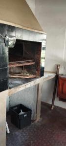 a brick oven with a black box on a wall at Casa, quincho, garage y parque.apta 10 personas in Mar del Plata