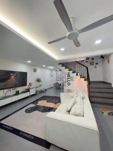 a living room with a white couch and a ceiling fan at Double storey and half 4r3b karaoke lami in Cheras