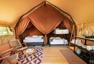 a room with a tent with two bunk beds at Huttopia Paradise Springs in Valyermo