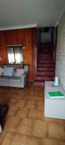 a living room with a couch and a staircase at Casa, quincho, garage y parque.apta 10 personas in Mar del Plata