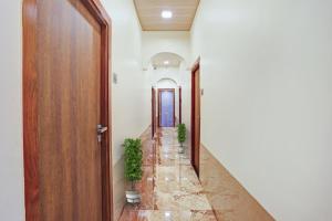 a hallway with a door and two potted plants at Malali Residency in Mumbai