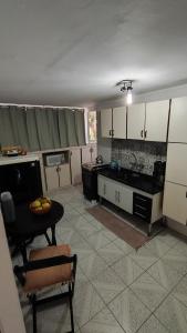 a kitchen with white cabinets and a table in it at Quarto Pernoite em apartamento Guarulhos Aeroporto Fast Sleep Individual in Guarulhos