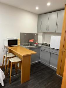 cocina con mesa de madera y microondas en Seculo apartments, en Oporto