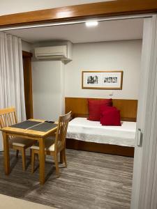 ポルトにあるSeculo apartmentsのベッド、テーブル、ベッドが備わる客室です。