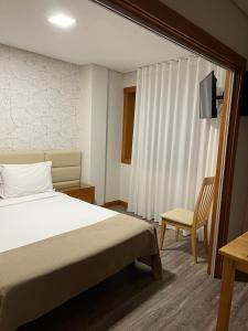 een slaapkamer met een bed, een stoel en een raam bij Seculo apartments in Porto