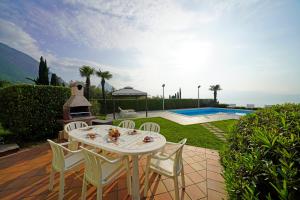 - une table et des chaises sur une terrasse à côté de la piscine dans l'établissement Villa Laura, à Toscolano Maderno