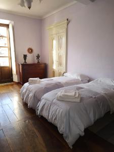 1 dormitorio con 2 camas y toallas. en La locanda del Castello con terrazzo, en Susa