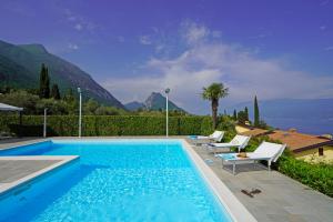 - une piscine avec des chaises et une vue sur les montagnes dans l'établissement Villa Laura, à Toscolano Maderno