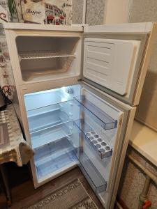 an empty refrigerator with its door open in a kitchen at Квартира LUX, Lux apartment in Taraz