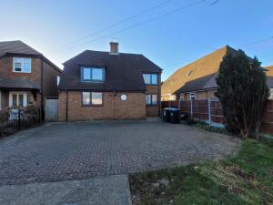a brick house with a brick driveway at Silvertree Lodge - 2 double bed flat with parking in Hemel Hempstead