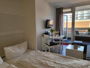una camera d'albergo con letto e tavolo con televisore di Apartment 35 im Haus Villa Anna a Sankt Peter-Ording
