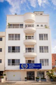 a white building with a blue sign on it at Hotel Castellana Real Cali in Cali