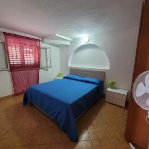 バリ・サルドにあるLa Casa Rosaのベッドルーム1室(青いベッド1台、赤い窓付)