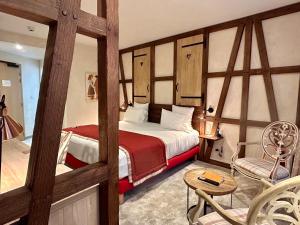 una camera con letto, tavolo e sedia di Hotel Beaucour a Strasburgo