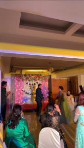 un grupo de personas viendo a un hombre bailar en una fiesta en Hotel Twins Residency en Thane