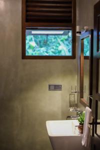 baño con lavabo blanco y ventana en Ran Villa en Hiriketiya