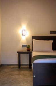 1 dormitorio con 1 cama y 1 mesa con reloj en la pared en Ran Villa en Hiriketiya