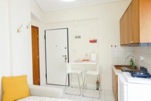 a kitchen with a table and two white chairs at Tiny Studio in Larisa +18 photos