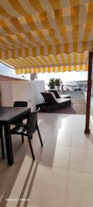 een patio met een tafel en stoelen onder een dak bij Beril D17 in Adeje