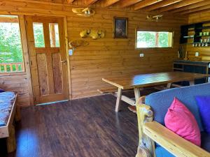 Ce chalet en bois dispose d'une table et d'un canapé. dans l'établissement Rio Manso cabaña km 18, à Río Villegas