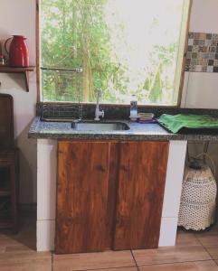 encimera de cocina con fregadero y ventana en Village verde, en Itacaré