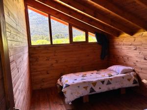 1 dormitorio pequeño con 1 cama en una cabaña de madera en El Manso km 18 en Río Villegas