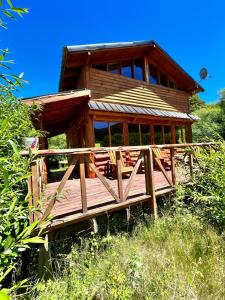 a large wooden house with a wooden deck at Rio Manso cabaña km 18 in Río Villegas