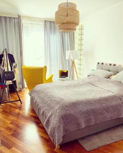 um quarto com uma cama e uma cadeira amarela em USTRONNE ZACISZE - Ustroń Zdrój Zeta Park em Ustroń