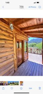 a wooden cabin with a door on a deck at Rio Manso cabaña km 18 in Río Villegas
