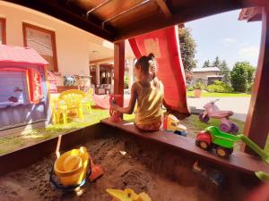 ein kleines Kind, das mit Spielzeug in einem Sandkasten spielt in der Unterkunft B&B Penzión Magura in Bardejov