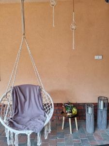 a hanging chair with a purple blanket on a patio at B&B Penzión Magura in Bardejov