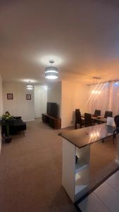 Habitación grande con sala de estar con mesa y sillas. en Amplio y Cómodo Departamento en Puerto Montt