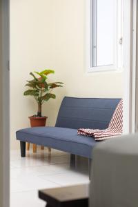 a blue bench in a room with a potted plant at Happy Nest Dominica in Marigot