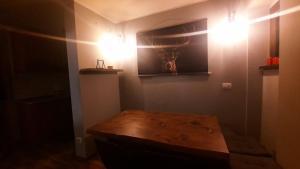 Cette chambre dispose d'une table en bois et de lumières murales. dans l'établissement Ski House Marmotta, à Borgata Sestriere 29 autres photos