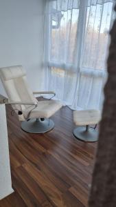 a salon with two white chairs and a window at Wohnen auf Zeit - perfekt für Grenzgänger, Wochenend-Heimkehrer und Berufsreisende in Schwörstadt