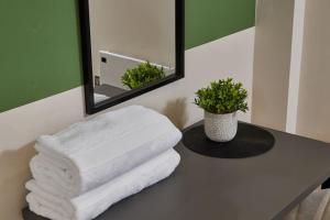 uma pilha de toalhas sentadas num balcão na casa de banho em Comfortable Leeds Flat - Ideal For Long Stays em Leeds