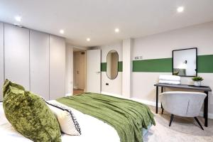 um quarto com uma cama, uma secretária e uma cadeira em Comfortable Leeds Flat - Ideal For Long Stays em Leeds