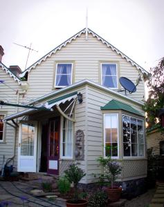 a white house with a green awning at Ellie's Place on City Park in Launceston