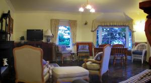 a living room filled with chairs and a tv at Ellie's Place on City Park in Launceston