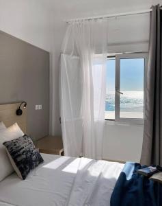 a bedroom with a bed and a large window at VistaMare2 Double room-sea view in Koutsourás +27 photos