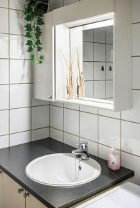 a white bathroom with a sink and a mirror at Studio apt in city centre in Trondheim