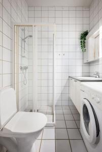 a white bathroom with a toilet and a shower at Studio apt in city centre in Trondheim