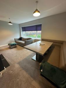 a living room with a table and a couch at Elwood - spacious contemporary home from home in Harrogate with parking in Harrogate