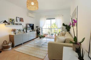ein Wohnzimmer mit Sofa und Tisch in der Unterkunft Casa Melo Apartment in Praia da Luz in Luz