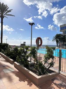 un complejo con una piscina y una palmera en Apto Playa Cañon del aguila, en San Bartolomé