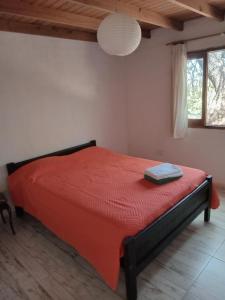 1 dormitorio con 1 cama roja en una habitación en Orquídeas en Quebrada de los Pozos