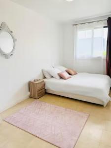 een slaapkamer met een bed met een tapijt en een raam bij Appt 70M2 Cosy et Famillial proche Paris in Ermont
