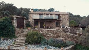 a stone house with a balcony on top of it at Casa Rural La Cordonera in Herguijuela