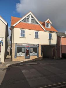 una gran casa blanca con garaje en una calle en Central Village flat, close to beach, en Milford on Sea